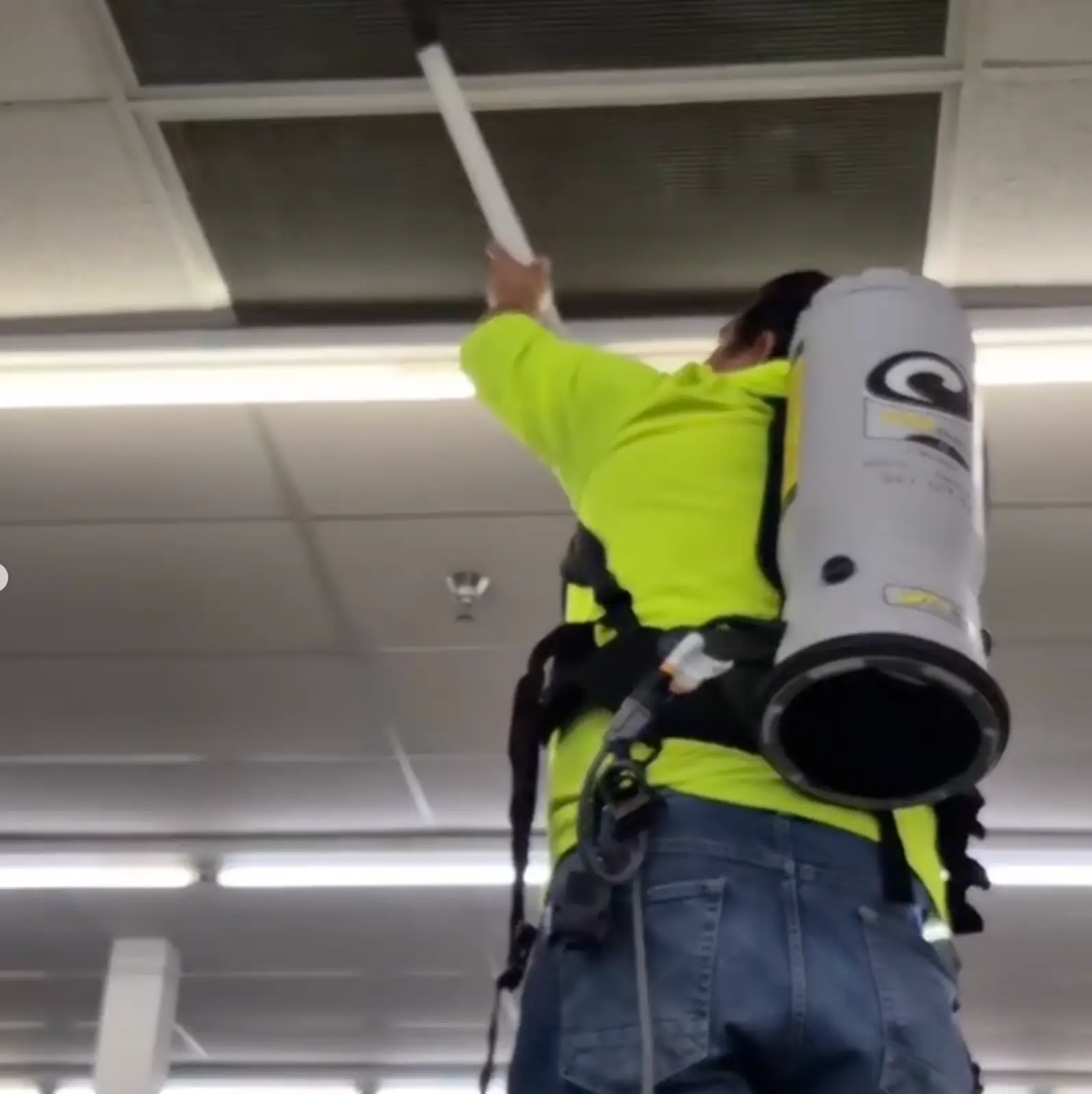 TONYGER team member cleaning a commercial ceiling with a backpack vacuum